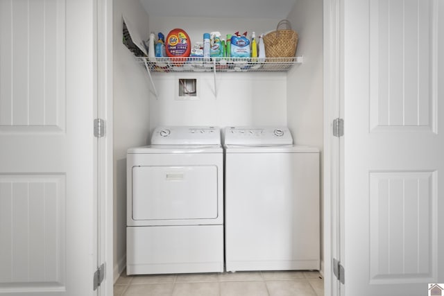 laundry room with washer and clothes dryer and light tile patterned flooring