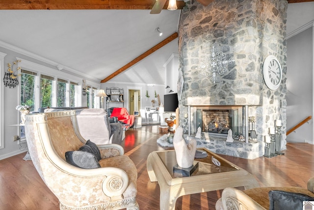 living room with beam ceiling, ceiling fan, crown molding, wood-type flooring, and a fireplace