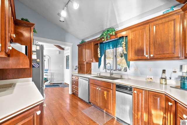 kitchen featuring sink, light hardwood / wood-style floors, lofted ceiling, and appliances with stainless steel finishes