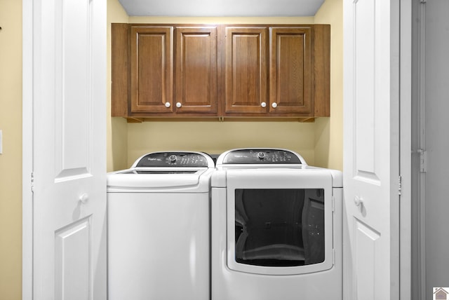 laundry room with washer and dryer and cabinets