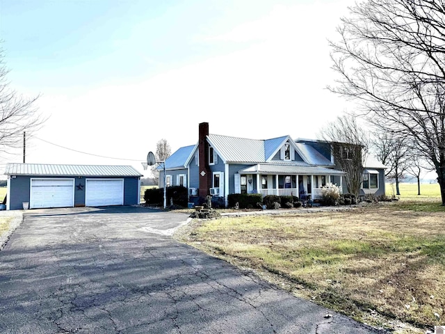 view of front facade featuring an outbuilding, a porch, and a garage