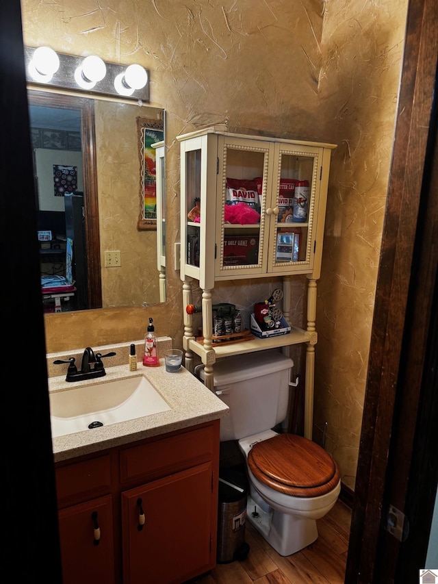 bathroom with vanity, toilet, and wood-type flooring