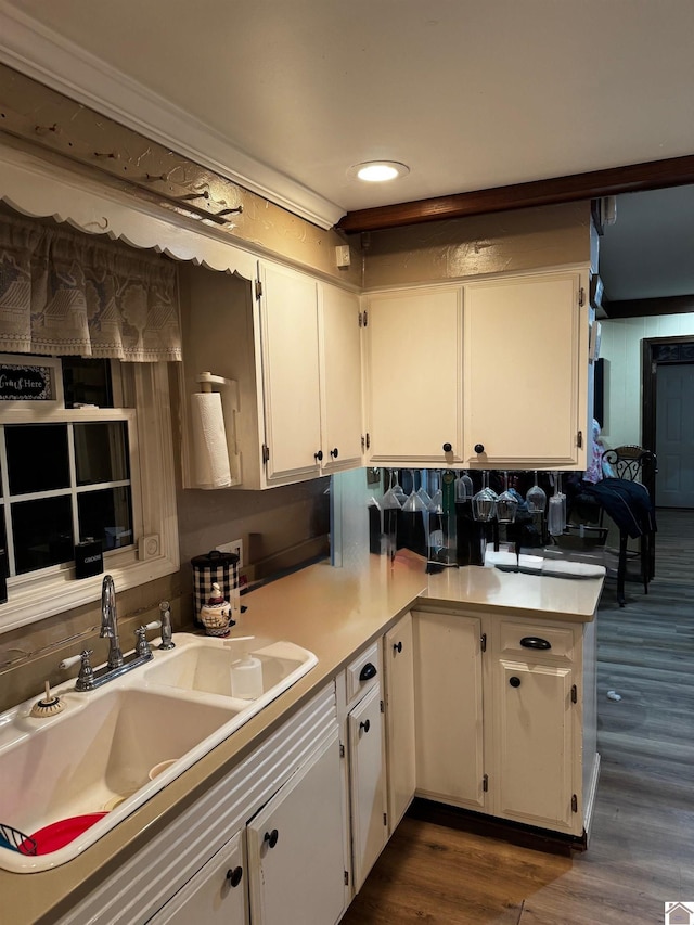 kitchen featuring kitchen peninsula, dark hardwood / wood-style flooring, sink, and white cabinets