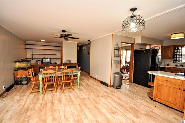 dining room with light hardwood / wood-style floors, ceiling fan, and sink