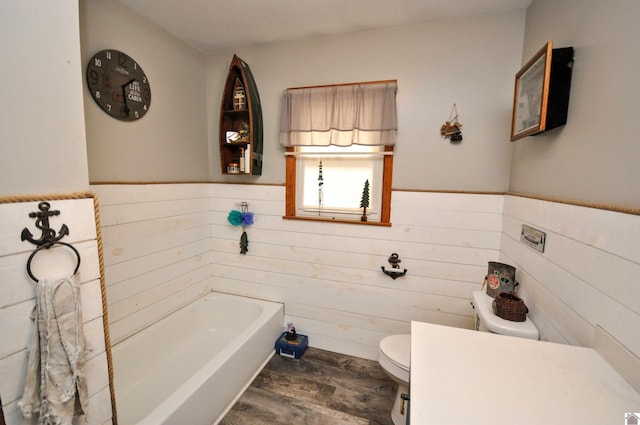 bathroom featuring a bathing tub, toilet, and hardwood / wood-style flooring