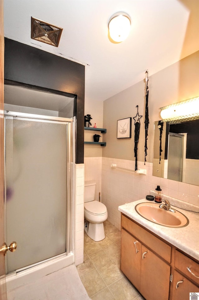 bathroom featuring an enclosed shower, vanity, tile patterned floors, and tile walls