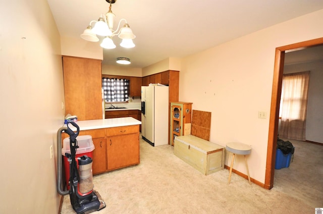 kitchen with plenty of natural light, light carpet, white fridge with ice dispenser, and decorative light fixtures