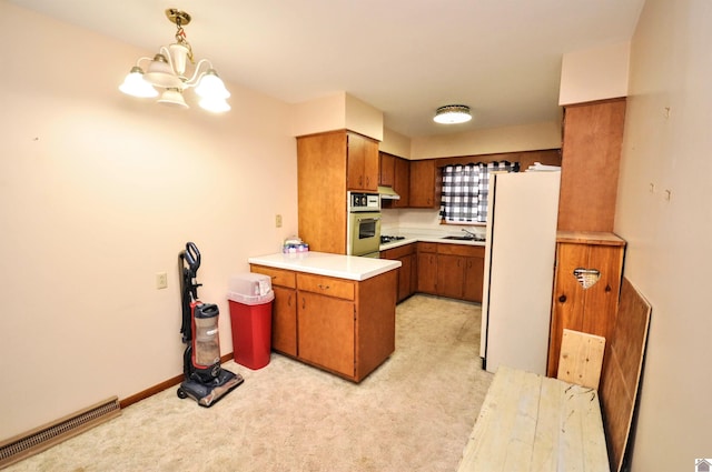 kitchen featuring light carpet, an inviting chandelier, white refrigerator, sink, and hanging light fixtures