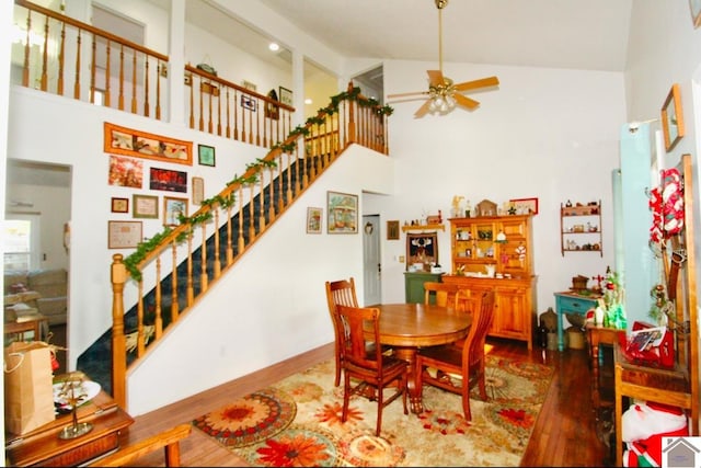 dining space featuring hardwood / wood-style flooring, ceiling fan, and high vaulted ceiling