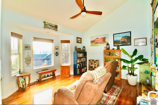 living room with ceiling fan, wood-type flooring, and vaulted ceiling