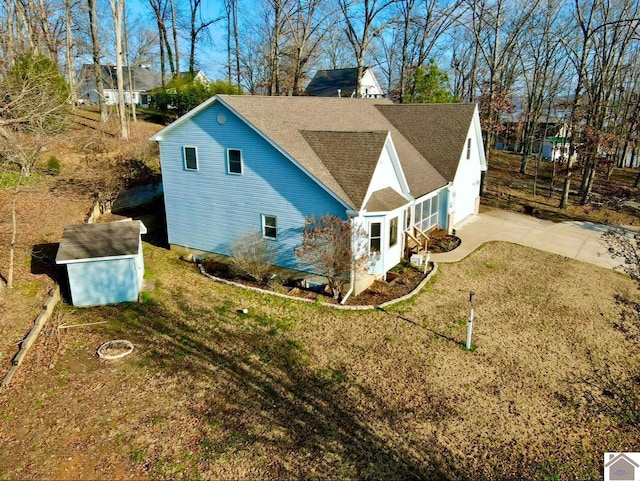 view of side of home featuring a shed and a yard