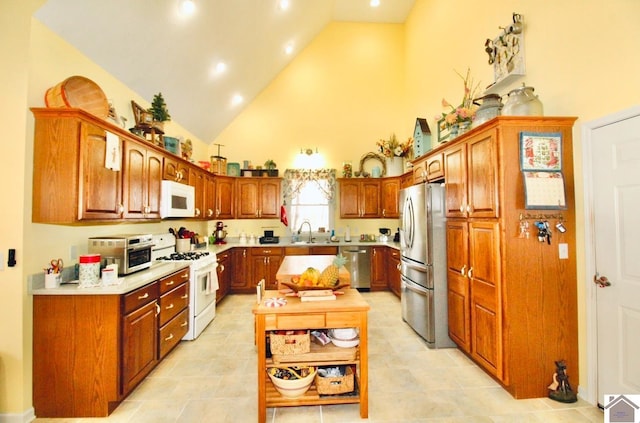 kitchen with sink, high vaulted ceiling, stainless steel appliances, and light tile patterned floors