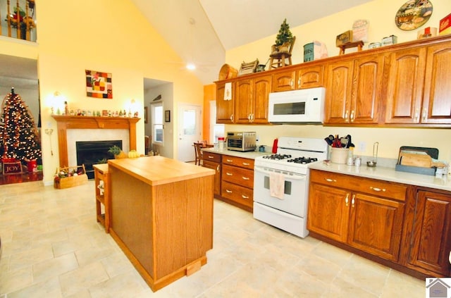 kitchen featuring ceiling fan, wood counters, high vaulted ceiling, white appliances, and a kitchen island