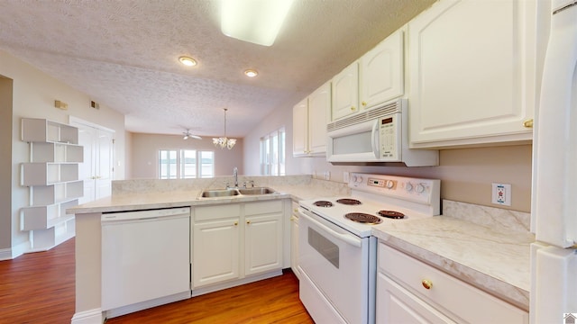 kitchen featuring kitchen peninsula, a textured ceiling, white appliances, sink, and light hardwood / wood-style flooring