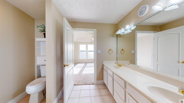 bathroom featuring tile patterned flooring, vanity, a textured ceiling, and toilet