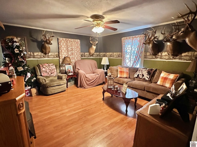 living room with crown molding, ceiling fan, and hardwood / wood-style flooring