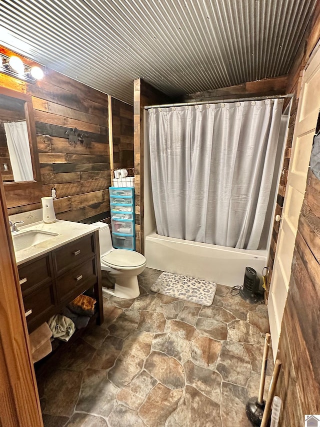 full bathroom with wooden walls, vanity, shower / bath combo, and toilet