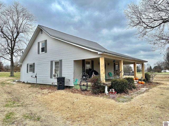 view of front of house with a porch, a front yard, and cooling unit