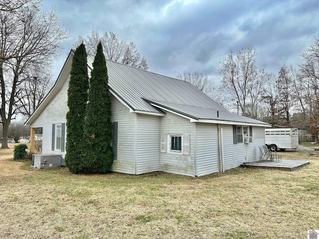 view of property exterior featuring a lawn, cooling unit, and central AC