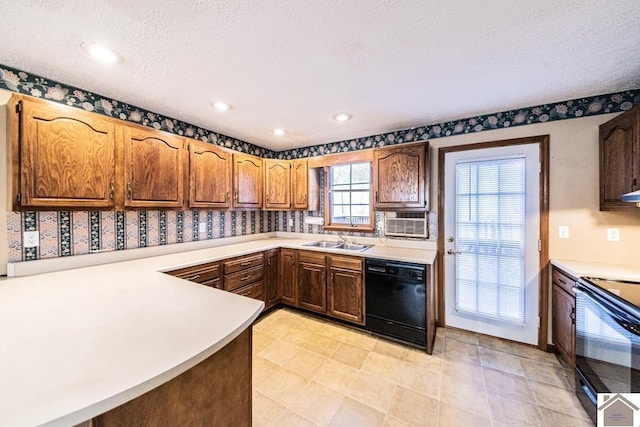 kitchen with kitchen peninsula, sink, black appliances, and a textured ceiling