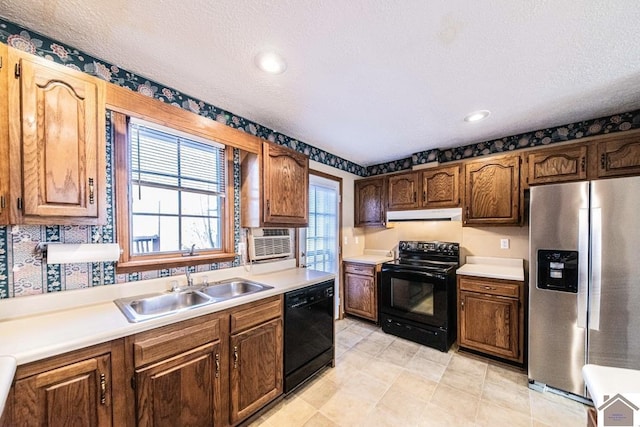 kitchen featuring a textured ceiling, sink, and black appliances