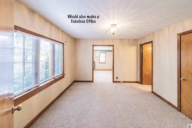 carpeted empty room featuring a textured ceiling