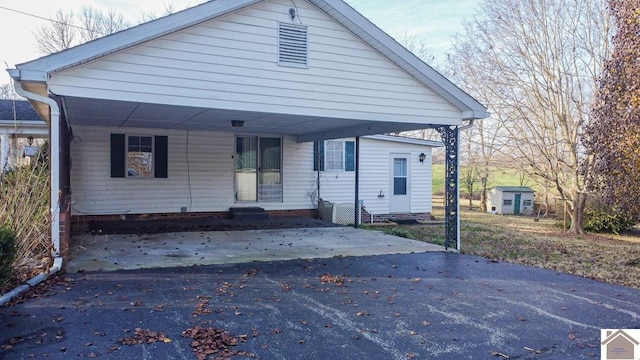 bungalow-style home featuring a storage unit and a carport