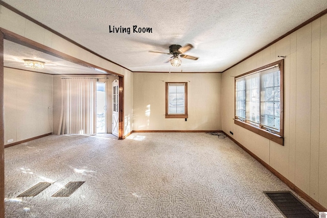 unfurnished room with plenty of natural light, ceiling fan, crown molding, and a textured ceiling