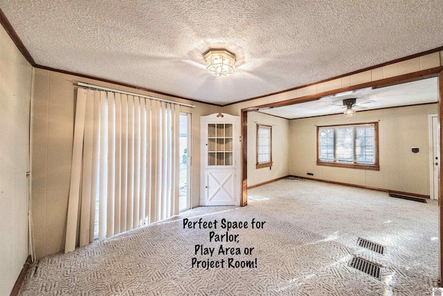 interior space featuring ceiling fan, plenty of natural light, and ornamental molding