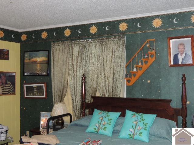 bedroom featuring a textured ceiling and crown molding