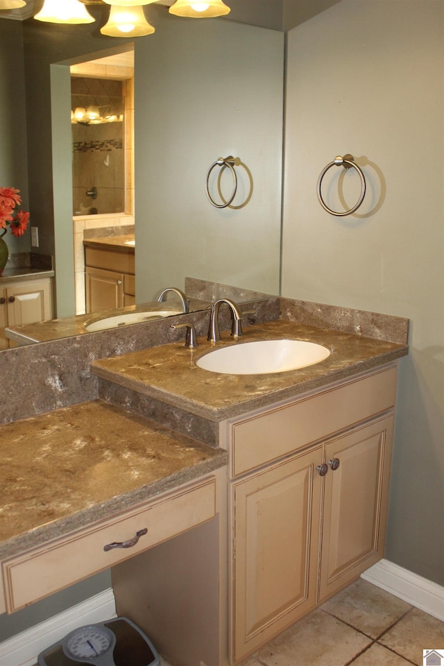 bathroom with a tile shower, tile patterned flooring, and vanity