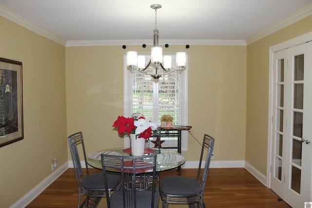dining room with dark hardwood / wood-style flooring, an inviting chandelier, and ornamental molding
