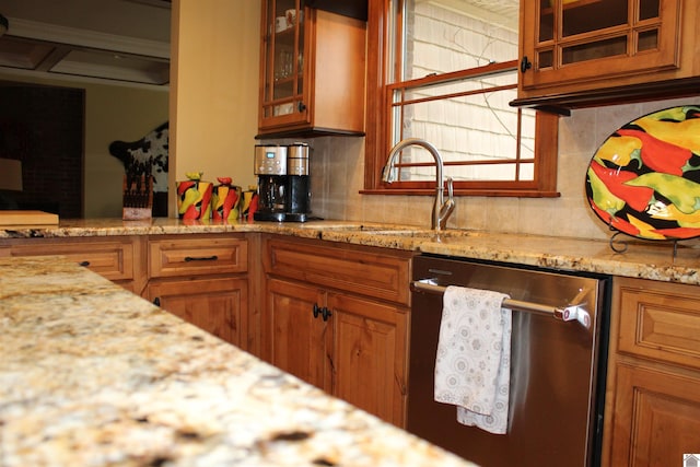 kitchen featuring decorative backsplash, sink, stainless steel dishwasher, and light stone counters