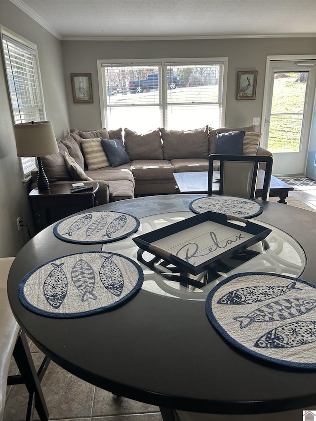 living room with tile patterned flooring, crown molding, and a healthy amount of sunlight