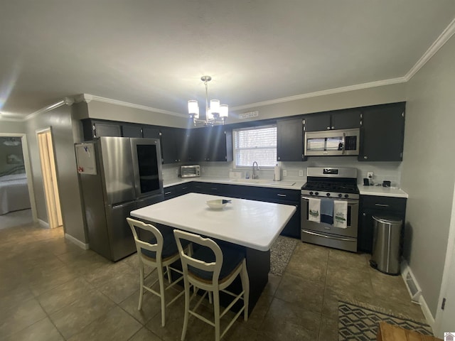 kitchen featuring a kitchen bar, stainless steel appliances, sink, pendant lighting, and a center island