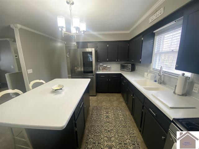 kitchen with a kitchen bar, stainless steel fridge, a kitchen island, and a notable chandelier