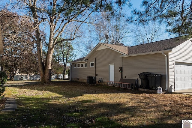 view of property exterior with a yard, cooling unit, and a garage