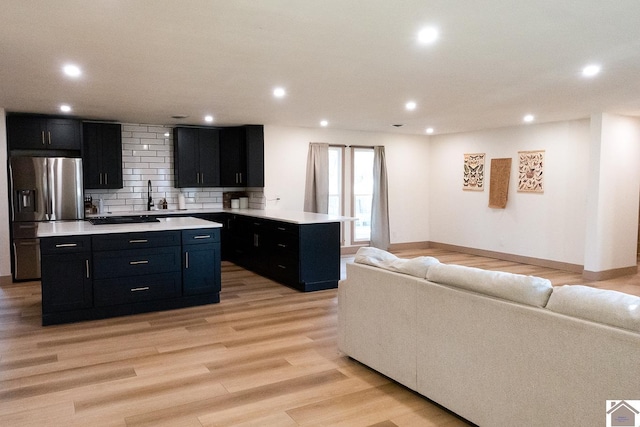 kitchen with tasteful backsplash, stainless steel refrigerator with ice dispenser, light hardwood / wood-style floors, black electric stovetop, and a kitchen island