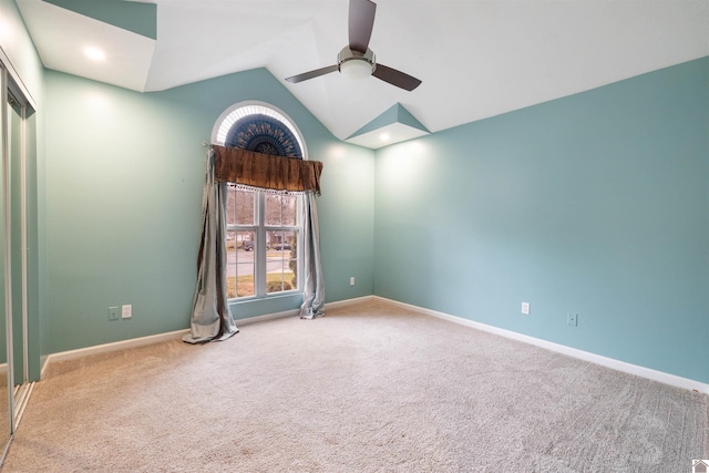 carpeted empty room with ceiling fan and lofted ceiling