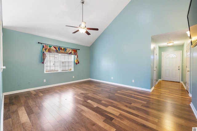 empty room with dark hardwood / wood-style flooring, high vaulted ceiling, and ceiling fan