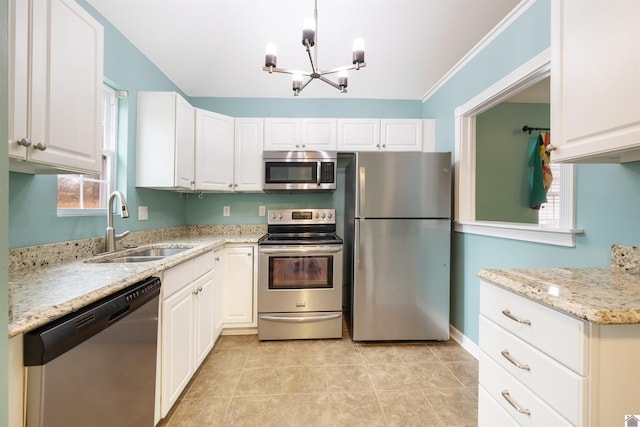 kitchen with appliances with stainless steel finishes, light stone counters, a healthy amount of sunlight, sink, and white cabinets