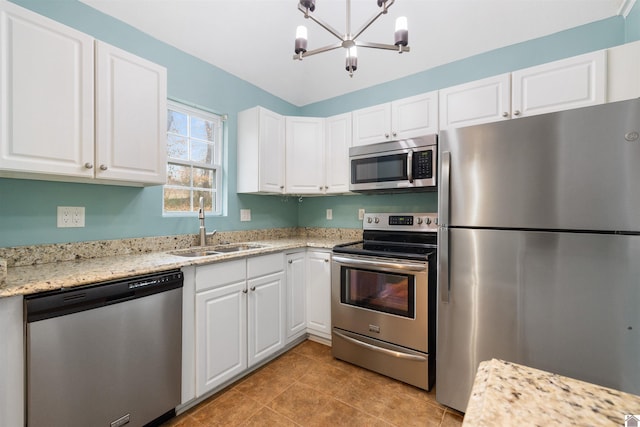 kitchen featuring light stone counters, sink, white cabinets, and stainless steel appliances