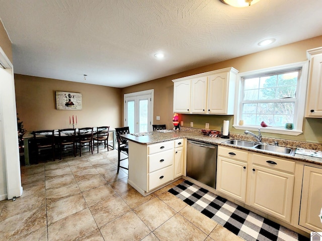 kitchen with sink, stainless steel dishwasher, kitchen peninsula, a textured ceiling, and light tile patterned floors