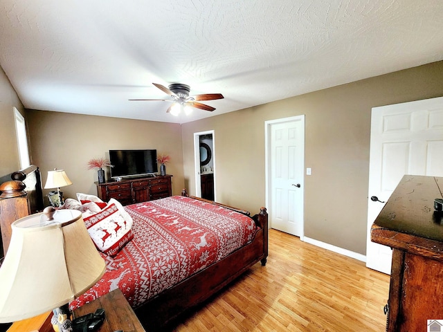 bedroom with ceiling fan, light hardwood / wood-style floors, and a textured ceiling