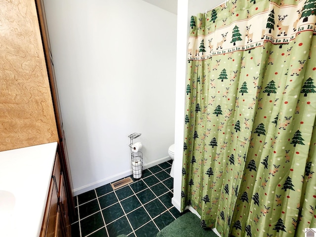 bathroom featuring tile patterned flooring, vanity, and toilet