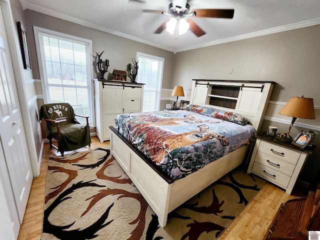 bedroom with multiple windows, ceiling fan, ornamental molding, and light wood-type flooring