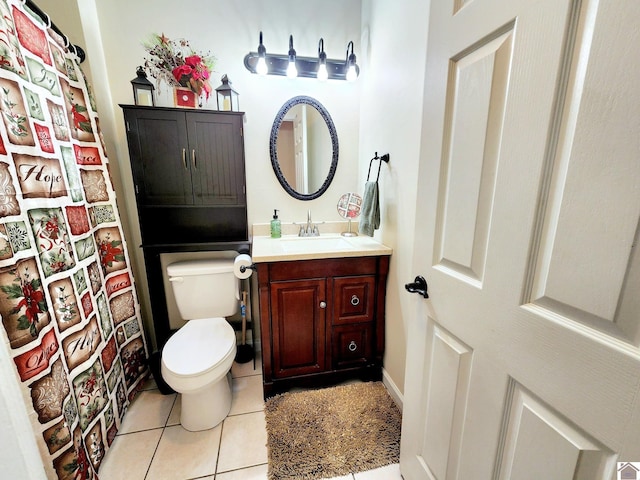 bathroom with toilet, vanity, and tile patterned floors