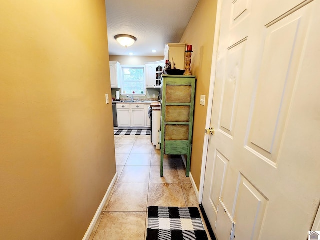 hallway featuring light tile patterned floors and sink