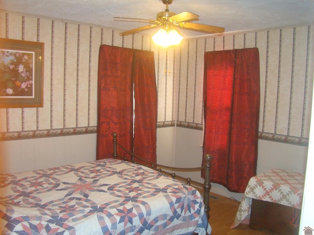 bedroom with ceiling fan and a textured ceiling