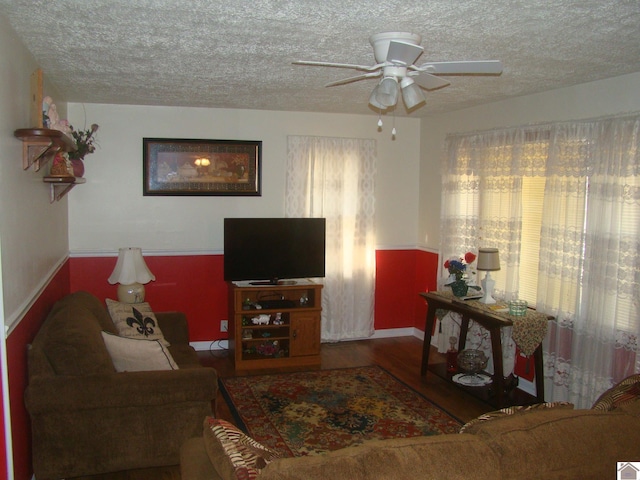 living room with hardwood / wood-style floors, ceiling fan, and a textured ceiling